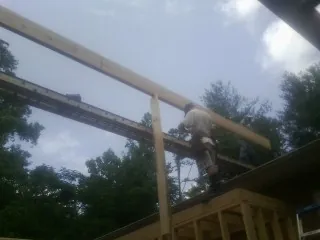 Carpenter setting a ridge beam over a new addition frame — Ice Dam Removal by Roofing Brothers in Morgan Hill