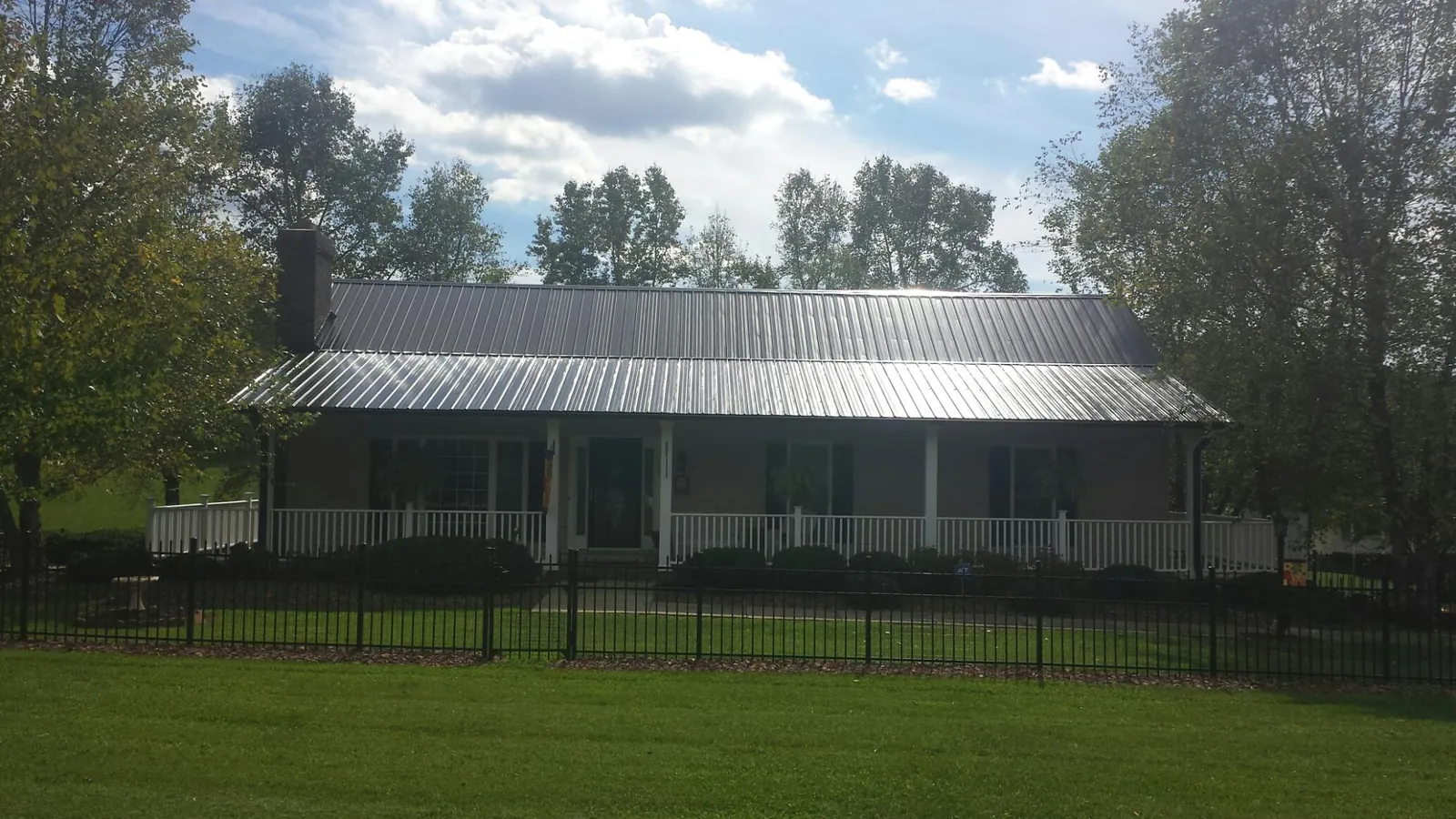 Gray metal roof on a brick ranch with a full width front porch — Gutter Guard Installation work by our crew in Morgan Hill